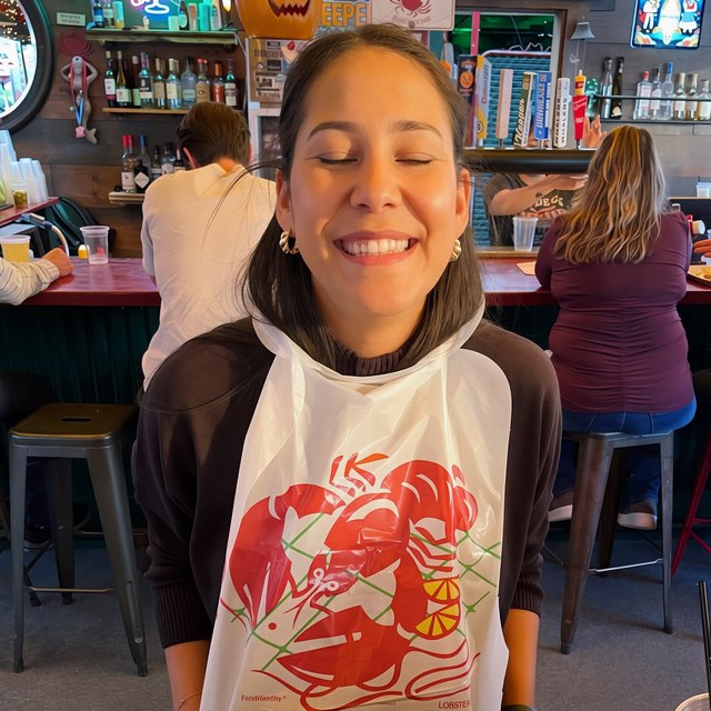 Andrea Block laughing in a lobster bib at a seafood restaurant