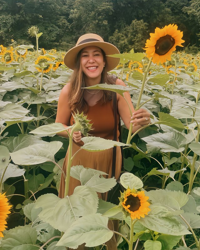 Andrea Block smiling in a sunflower field, Squarespace website designer and AI and SEO search expert